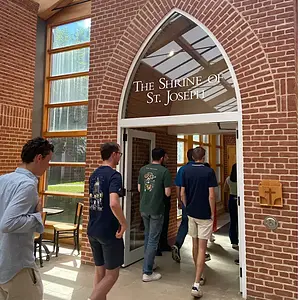 Group enters the Shrine of St. Joseph through a brick archway.